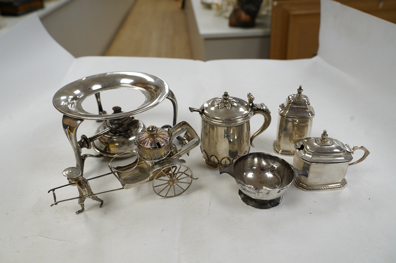 Five assorted silver condiments, including Chinese white metal modelled a rickshaw, together with a plated tea kettle stand with burner. Condition - poor to fair